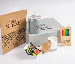 Branded “Take a Break” gift set with insulated tumbler, scented candle, snacks, and card.
